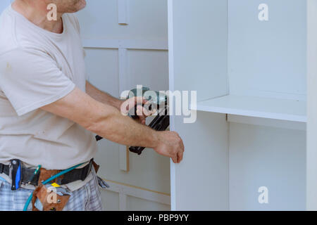 Man installing wooden shelves on brackets wall installing a shelf
