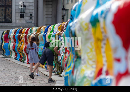 RIGA, LATVIA - JULY 26, 2018: United Buddy Bears exhibition. City residents and tourists are looking at and photographing the exhibition at the Old To Stock Photo