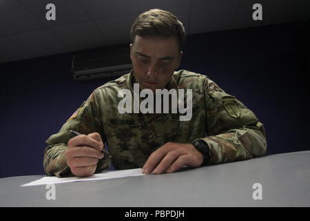 Sgt. John Gilleland, from the Maneuver Center of Excellence, takes the written exam portion of the TRADOC Best Warrior Competition, Fort Gordon, Georgia, July 19, 2018. The Best Warrior Competition recognizes TRADOC NCOs and Soldiers who demonstrate commitment to the Army Values, embody the Warrior Ethos, and represent the force of the future by testing them with physical fitness assessments, written exams, urban warfare simulations, and other warrior tasks and battle drills. (U.S. Army photo by Staff Sgt. Daniel Luksan) Stock Photo