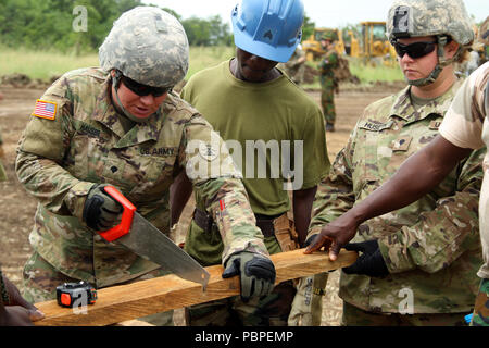 Soldiers with the North Dakota National Guard team up with the Ghana Armed Forces to assemble structures at the Bundase Training Camp, Ghana, during United Accord 2018 at the  July 20, 2018. UA18 is a Ghana Armed Forces & U.S. Army Africa hosted exercise consisting of four combined, joint components: a computer-programmed exercise (CPX), field training exercise (FTX), Jungle Warfare School (JWS) and medical readiness training exercise (MEDRETE). West-African partner militaries, NATO Allies and U.S. Army Africa will execute each component in Accra, Ghana and surrounding areas. (U.S. Army Photo  Stock Photo