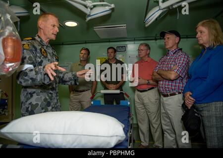 180720-N-VR594-1216 PACIFIC OCEAN (July 20, 2018) Royal Australian Navy Lieutenant Commander Richard Classon, senior health officer, from Perth, Australia, gives a tour of medical to U.S. representatives during a visit aboard the landing helicopter dock ship HMAS Adelaide (L01) during the Rim of the Pacific (RIMPAC) exercise, July 20. Twenty-five nations, 46 ships, five submarines, and about 200 aircraft and 25,000 personnel are participating in RIMPAC from June 27 to Aug. 2 in and around the Hawaiian Islands and Southern California. The world's largest international maritime exercise, RIMPAC  Stock Photo