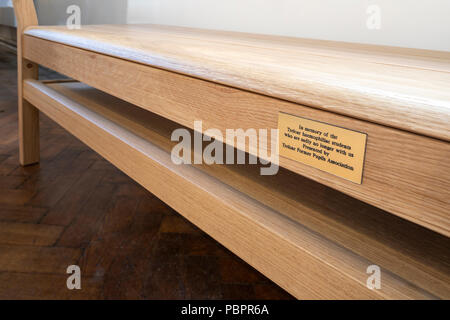 Holybourne, Hampshire, 28 July 2018. A solid oak pew in the Church of the Holy Rood in Holybourne, near Alton, Hampshire dedicated on Saturday 28th July 2018 to the memory of the haemophiliacs who died as the result of being treated with contaminated blood products while at the nearby Treloar College.  It is thought that 72 pupils have died out of 89 infected.  The inscription reads,'In memory of the Treloar haemophiliac students who are sadly no longer with us. Presented by Treloar Former Pupils Association' Stock Photo