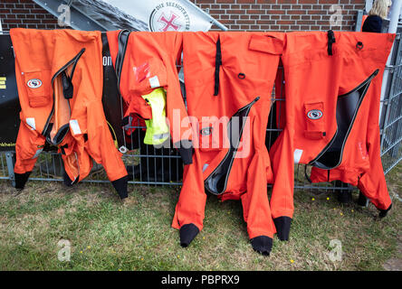 Wilhelmshaven, Germany. 29th July, 2018. Suits of the German Society for the Rescue of the Shipwrecked (DGzRS) hanging on a lattice fence. Credit: Mohssen Assanimoghaddam/dpa/Alamy Live News Stock Photo