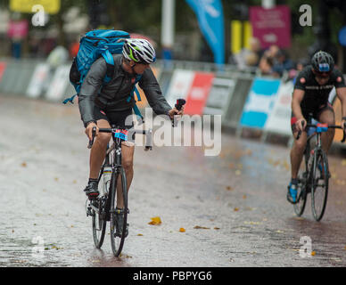 The Mall, London, UK. 29 July, 2018. Cyclists taking part in the London-Surrey 100 and 46 races enter the finish straight in wet weather after weeks of heatwave. Credit: Malcolm Park/Alamy Live News. Stock Photo