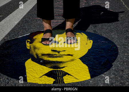 Moscow, Russia. 29th, July, 2018. A protester step on a sticker with an image of Russian President Vladimir Putin during a rally against the government's proposed reform hiking the pension age in Moscow, Russia Credit: Nikolay Vinokurov/Alamy Live News Stock Photo
