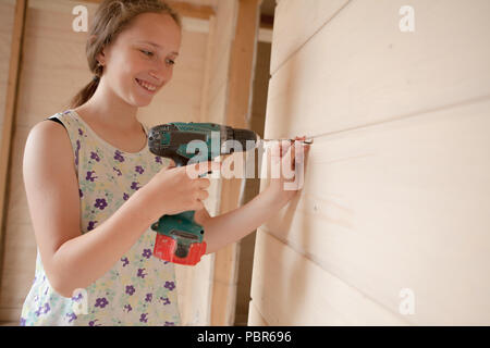 Close-up the woman holding the screw and the electric screw-driver. Stock Photo