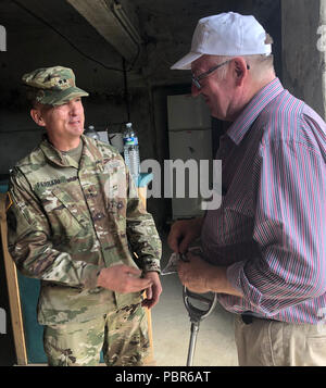 SThe commander of the Nerw York National Guard's 42nd Infantry Division, Major General Steven Ferrari, hands the owner of the Musarde Farm  a Division coin for his generosity to 25 division  oldiers by hosting a picnic for them and a tour of the farm on July 25, 2018. On October 14, 1918, the division's 167th Infantry Regiment took the farm during an assault on German fortifications.Twenty-five members of the New York Army National Guard's 42nd Infantry Division, which is headquartered in Troy, headed to France on Monday, July 23 to take part in a week of World War I commemorative activities.  Stock Photo