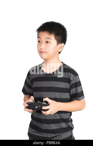Asian boy holding radio remote control (controlling handset) for helicopter, drone or plane, studio shot isolated on white background. Stock Photo