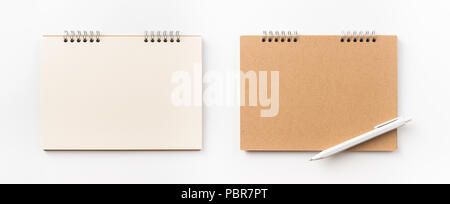Design concept - Top view of kraft spiral notebook, blank page and pen isolated on white background for mockup Stock Photo