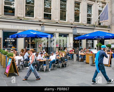 Social cafe restaurant, Royal Exchange Square busy at lunchtime with man taking selfie and people walking by, Glasgow, Scotland, UK Stock Photo
