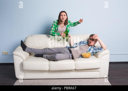 Sad friends or football fans watching soccer on tv. Losing a favorite team Stock Photo