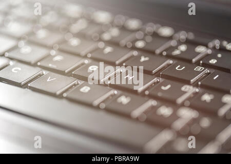 Macro view of black laptop keyboard buttons against back light Stock Photo