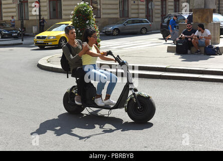 Teenagers teenage youths riding electric scooters in Prague in the Czech Republic Stock Photo