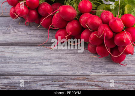 Fresh bright radish on a dark wood. Copy space. Food background. Stock Photo