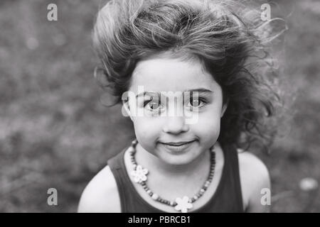 Black and white Portrait of cute little girl smiling outside Stock Photo