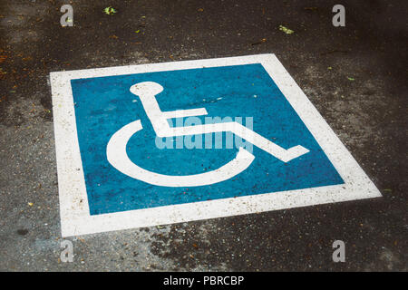 Blue and white disabled design painted on the ground, public parking lot, vintage look, usa. Stock Photo