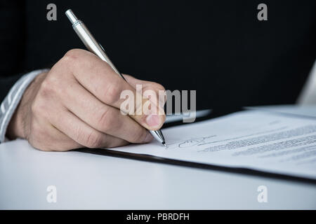 Businessman signing a contract close up view from behind Stock Photo
