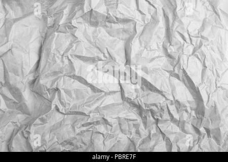 highly crumpled gray paper sheet with dents. Stock Photo