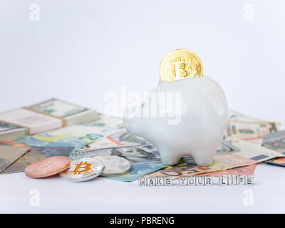 Bitcoins, New Virtual Money concept in piggy bank. Gold bitcoins with name Make Your Life on dollars' euros' background. Golden coins with icon letter Stock Photo
