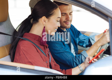 Delighted Asian woman using her smartphone Stock Photo