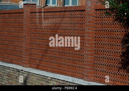 Red coloured compound wall (made of terracotta tiles) of a house. Rome, Italy, Europe Stock Photo