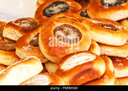 Fresh pastries for sale in a bakery. Sales of different types of cakes in the farmers' markets. Sweet pastry at the market. Apricot, poppy, marmalade  Stock Photo