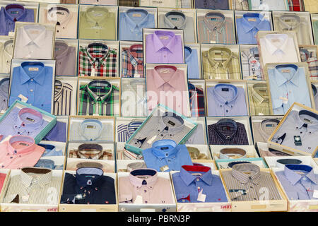 A display of men's shirts in their plastic and cellophane packaging stacked one of above the other Stock Photo