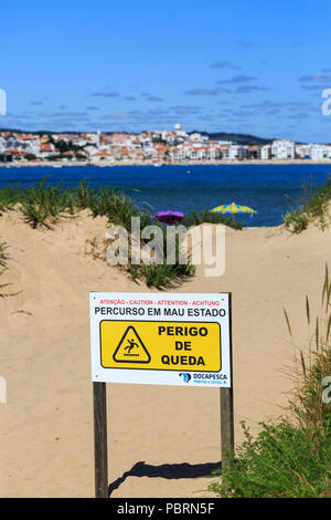 Sign in Portuguese on the beach at Sao Martinho do Porto stating that the path is in poor condition and there is a danger of falling. Stock Photo