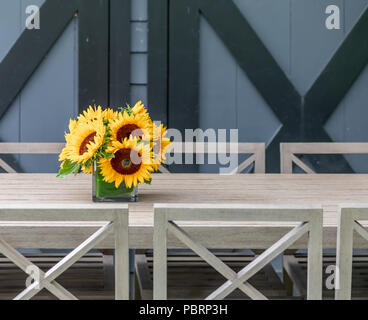 vase with fresh cut sunflowers on an outdoor table with black and grey background Stock Photo