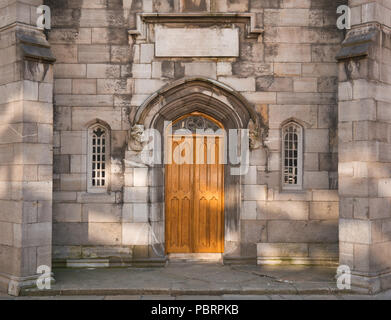 An entrance with a gold-painted wooden door and a window on each side Stock Photo