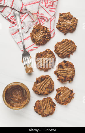 Vegan oatmeal cookies with peanut butter on white background, top view. Healthy vegan food concept. Stock Photo