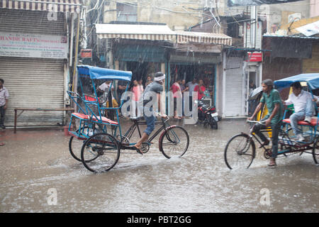 Bicycle rickshaws trying to get through the flooded streets during monsoon rains in New Delhi, India. Stock Photo