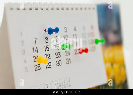 Colorful pins push marking on a calendar. Busy schedule Stock Photo