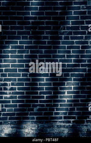 Brick wall of building with dark shadows of trees cast on it. Stock Photo