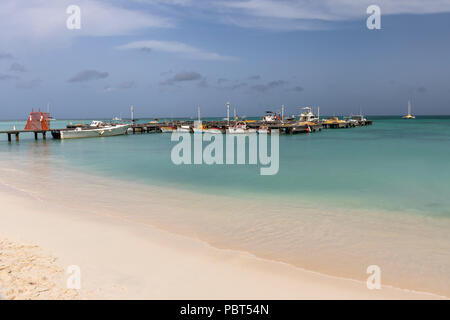 Fishing boats moored in the turquoise Caribbean sea at Palm Beach, Aruba, Caribbean Stock Photo