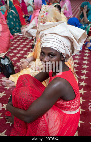 A Nigerian guest at a Sikh wedding wearing a traditional Nigerian hat in Richmond Hill, Queens, New York. Stock Photo