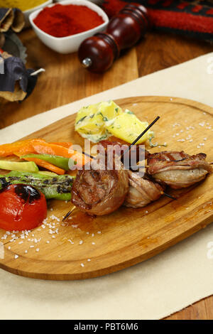 Turkish Street Food Kokorec made with sheep bowel with skewer on plate Stock Photo