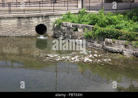 Stormwater drainage culvert on the dupage  River walk in Chicago suburb Naperville, Illinois on a bright sunny summer day. Stock Photo