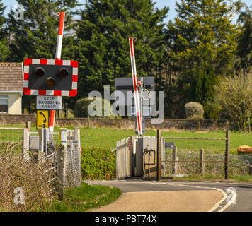 Unmanned railway crossing with automatic barriers on a road at Pontsarn, near Cardiff Stock Photo