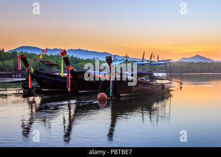 Pak Meng, Thailand-21st Februsry 2016: Long tail boats moored at sunrise. The boats are used for fishing or tourist boat trips. Stock Photo