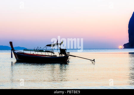 Silhouette of man on long tail boat at sunset, Pak Meng, Trang Province, Thailand Stock Photo