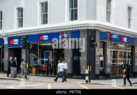 Pedestrians walking past the branch of the Metro Bank on Bishopsgate, City of London on the corner with Liverpool Street. England, UK Stock Photo