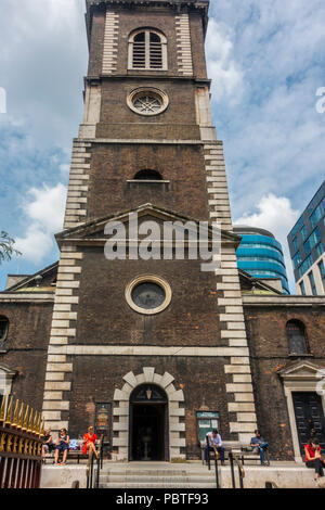 People sitting outside St Botolph without Aldgate, a Church of England parish church finished 1744, made of brick with stone quoins. Stock Photo