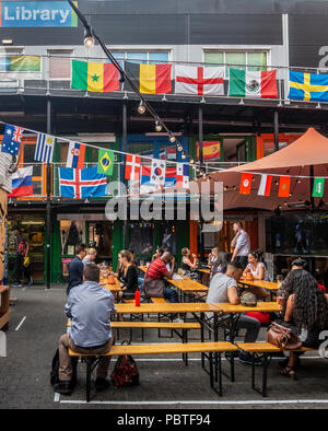 Customers eating at The Artworks, a collective of eating places and small businesses operating out of old shipping containers; Elephant and Castle, Stock Photo