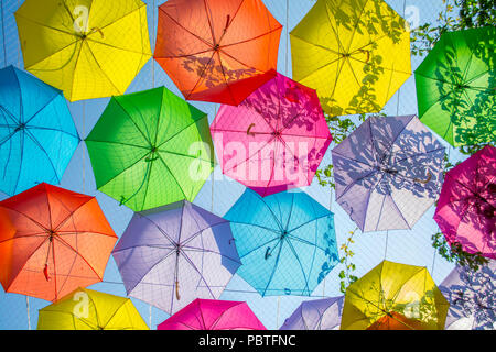 Multi-colored umbrellas background. Colorful umbrellas floating above the street. Street decoration. Stock Photo