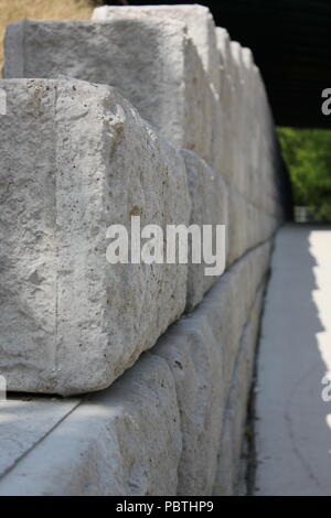 A wall of concrete masonry blocks lining the path. Stock Photo
