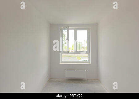 Empty unfinished room with window in a new constructed building Stock Photo