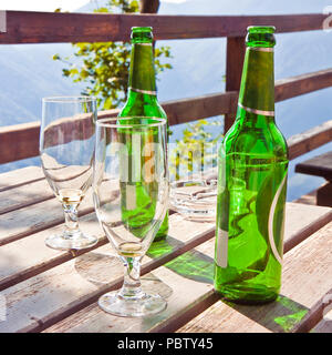 Two empty beer bottles with glasses on a wooden table - image with copy space Stock Photo