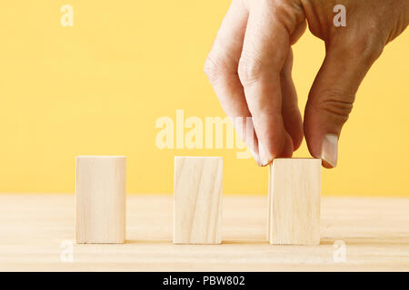man hand picking a blank wooden block. empty blocks for mock up Stock Photo