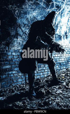 Stalker in gas mask, armed with gun in dungeon Stock Photo